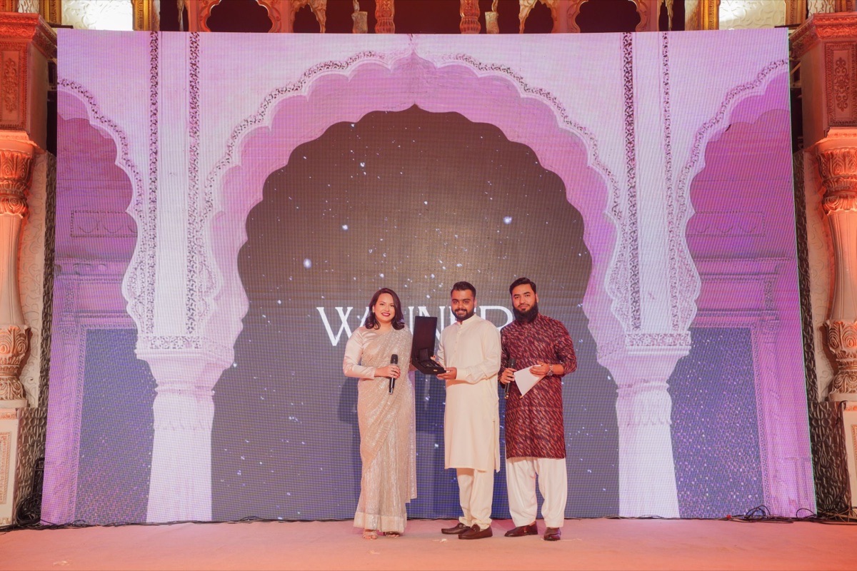 Anas receiving the Excellence in Action Award on stage at SpurSol's Annual Awards.